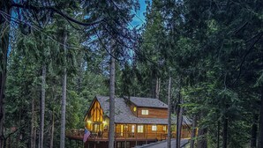 Une cabane en bois avec une allée sinueuse, entourée de grands arbres.