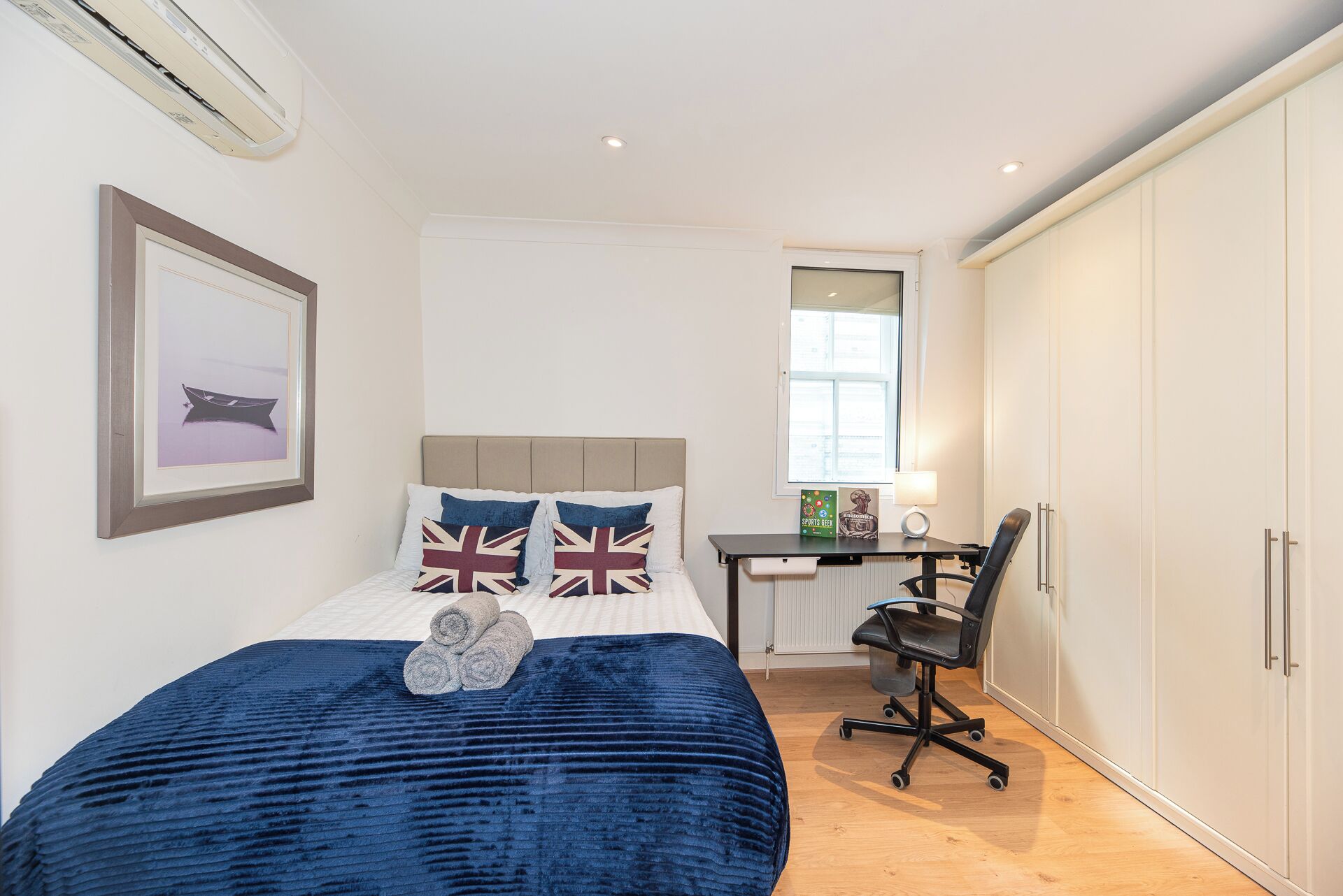 Une chambre à coucher avec un lit, un bureau et une armoire.