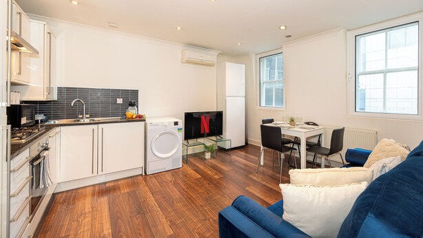 Um apartamento moderno com cozinha, sala de jantar e sala de estar.