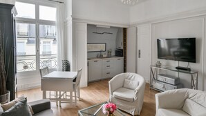 Una sala moderna con comedor, cocina y televisor.