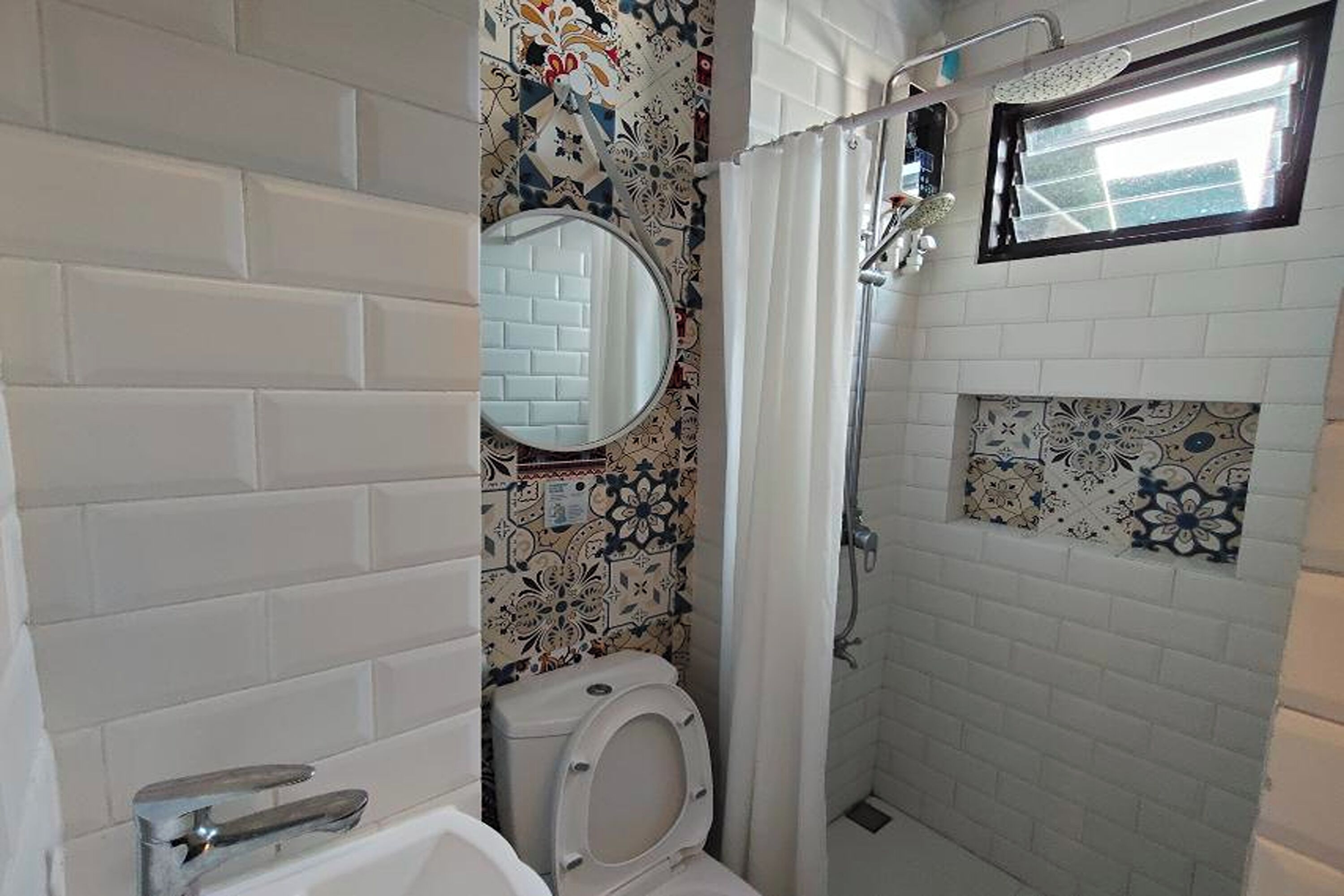 A bathroom with a white toilet, a shower with a glass door, and a mirror above the toilet.
