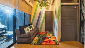 A modern interior with a sofa, a colorful wall, and a door. - Redenza Suites Makati (Makati)