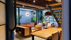 A cozy cafe with wooden furniture, a large window, and a staircase. - w Prestigious Duplex w Perfect Deco in Poblado (Medellín)