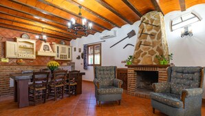 A rustic interior with a stone fireplace, wooden furniture, and a tiled floor. - Beautiful home in Priego De Cordoba (Priego De Cordoba)
