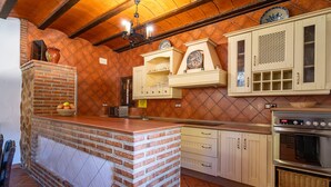 A kitchen with a brick island, white cabinets, and a built-in oven. - Beautiful home in Priego De Cordoba (Priego De Cordoba)