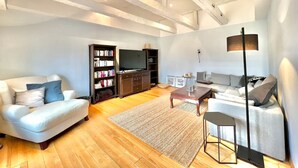 Un salon moderne comprenant un canapé, une table basse, une bibliothèque et un téléviseur.