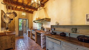 A rustic kitchen with exposed brick walls, wooden beams, and a brick floor. - SCAPPO IN UMBRIA, la quiete farmhouse (Umbria)