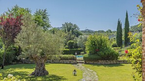 A well-maintained garden with a stone pathway leading to a pool area, surrounded by various trees and shrubs. - SCAPPO IN UMBRIA, la quiete farmhouse (Umbria)