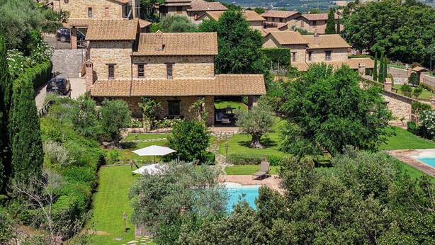 A stone building with a swimming pool, surrounded by lush greenery and a view of the countryside. - SCAPPO IN UMBRIA, la quiete farmhouse (Umbria)