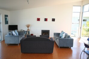 Relax by the fireplace in this stylish living room, featuring a flat-screen TV and comfortable seating for three.