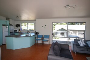 Relax and dine in this open-plan living space with a central island and adjacent patio access.