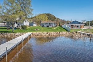 A lakeside property with a dock, a house, and a small building.