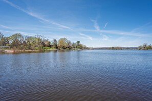 A lake with a clear sky, trees, and buildings in the background. - Lake WI Escape! Explore, Boat, Swim & Hike (Lodi)