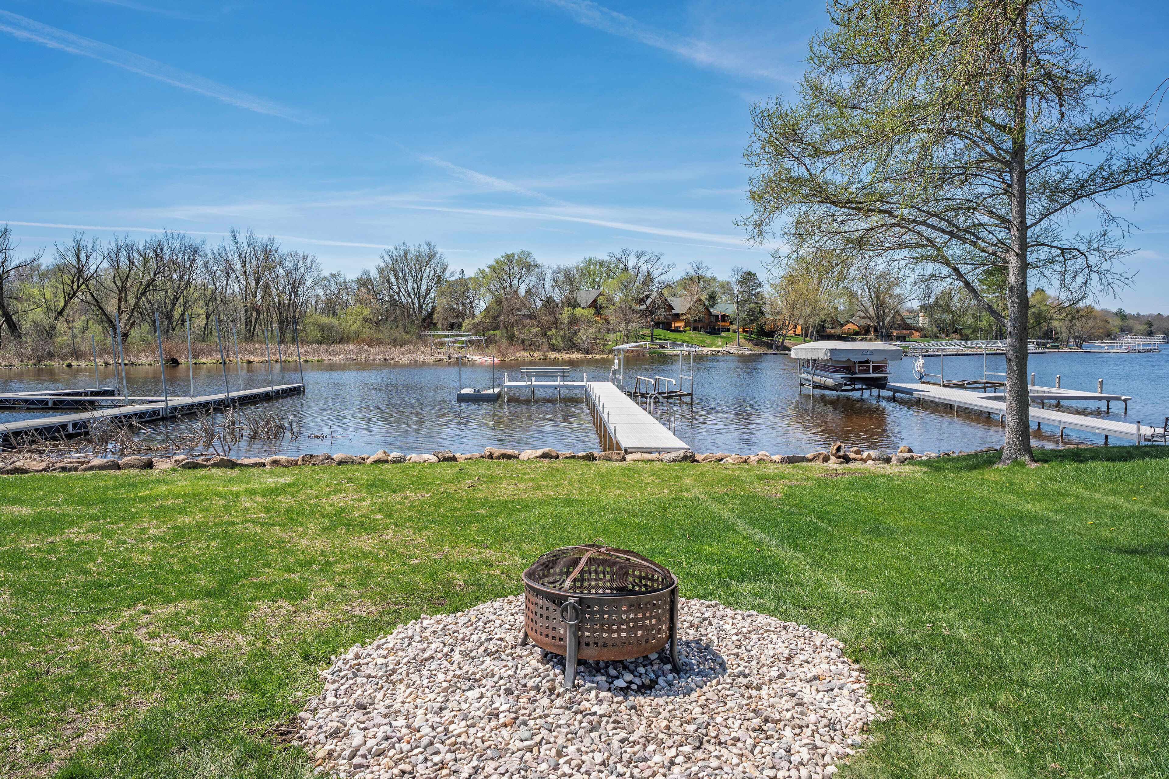 A lakeside view with docks, a boat, and a picnic area.