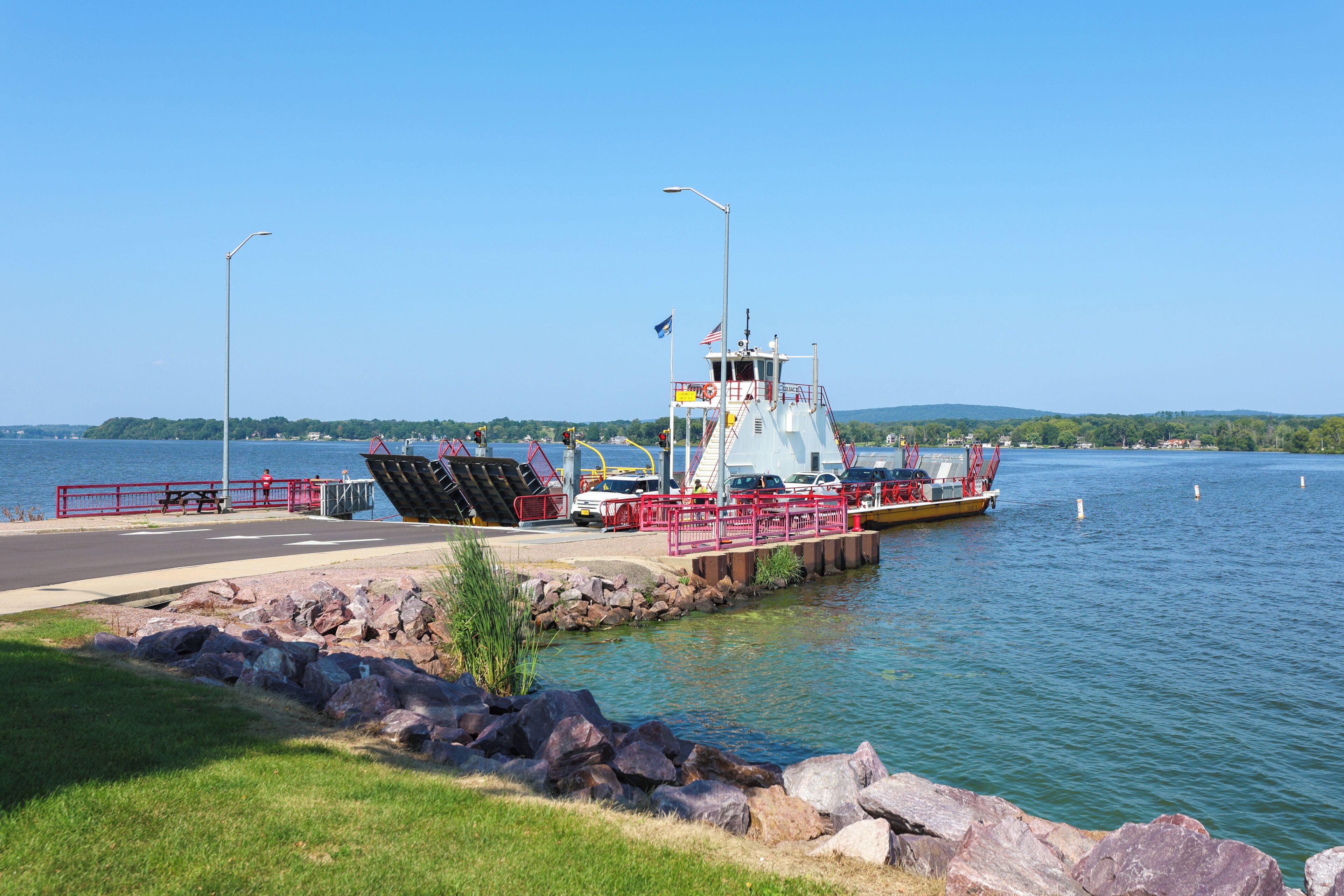 A ferry dock with a clear view of the water and a distant shoreline.