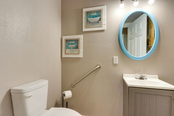 A bathroom with a toilet, sink, and a mirror. There are two framed pictures on the wall. - 4 Mi to Pomme De Terre Lake: Large Home w/ Patio! (Hermitage)
