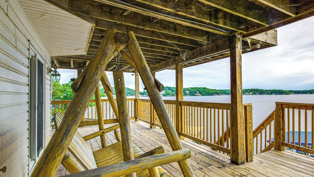 Eine Holzterrasse mit Blick auf einen Fluss und Hügel im Hintergrund.