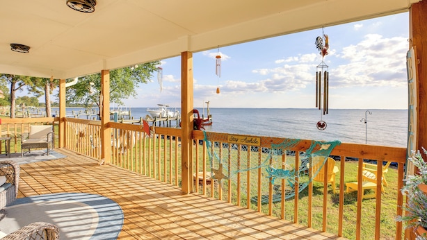 A wooden deck with outdoor furniture, a view of the sea, and a sign that reads "Stay Afloat". - Pet-friendly Maryland Home on the Potomac River! (Leonardtown)