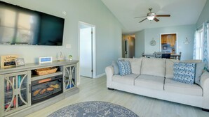 A living room with a sofa, TV, and ceiling fan. - Pet-friendly Maryland Home on the Potomac River! (Leonardtown)