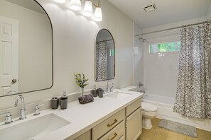 A modern bathroom with two sinks, a large mirror, and a shower area. - Family Home w/ Game Room & Deck in Spring! (The Woodlands)