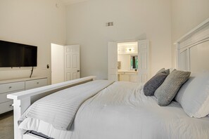 Relax in a spacious bedroom with a large bed, flat-screen TV, and comfortable seating.