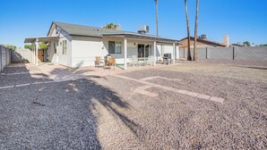 A single-story house with a covered patio, a small lawn, and a gravel driveway. - 8 Mi to State Farm Stadium: Glendale Home w/ Grill (Peoria)