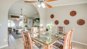A dining area with a glass-top table, patterned chairs, and a ceiling fan. - 8 Mi to State Farm Stadium: Glendale Home w/ Grill (Peoria)