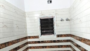 A small, compact bathroom with a toilet, shower, and a window.