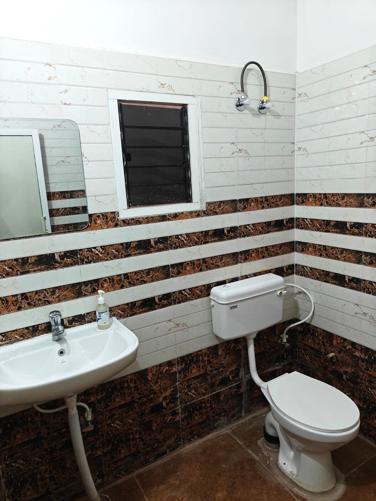 A bathroom with a white sink, toilet, and a window with a black shutter.