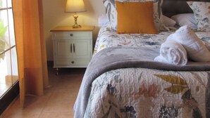 A bedroom with a bed, a nightstand, a lamp, and a painting on the wall. - Perfect for your meetings, adequate space, beautiful, functional, well equipped. (Urda)