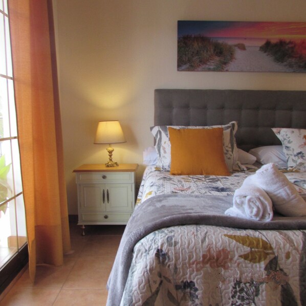 Une chambre à coucher avec un lit, une table de chevet, une lampe et un tableau au mur.