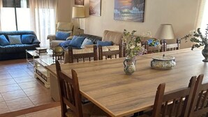 A dining area with a wooden table and chairs, a sofa, and a coffee table. - Perfect for your meetings, adequate space, beautiful, functional, well equipped. (Urda)