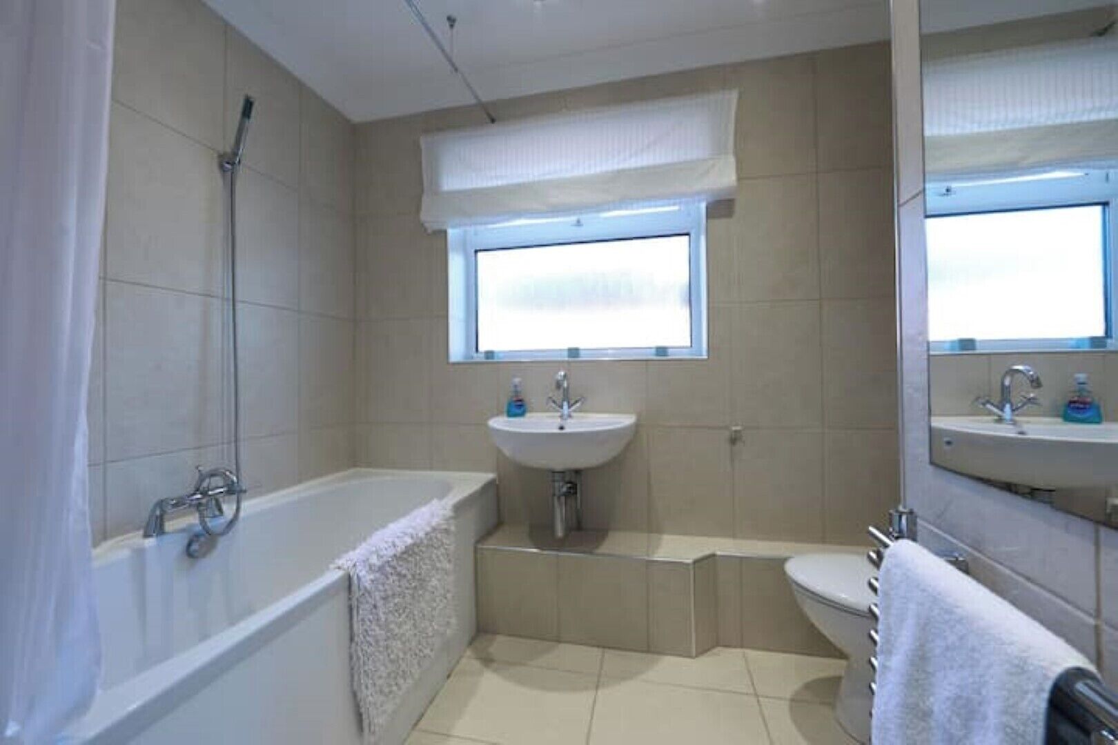 A bathroom with a bathtub, a sink, and a shower.