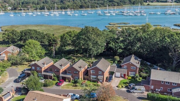 Un barrio residencial con casas y un puerto deportivo con barcos.