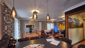 Un comedor moderno con una mesa de madera, sillas e iluminación colgante.