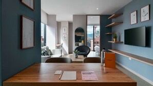 A modern interior with a wooden table, framed artwork, and a flat-screen TV. - w Spectacular Loft w Balcony in El Nogal (Bogotá)