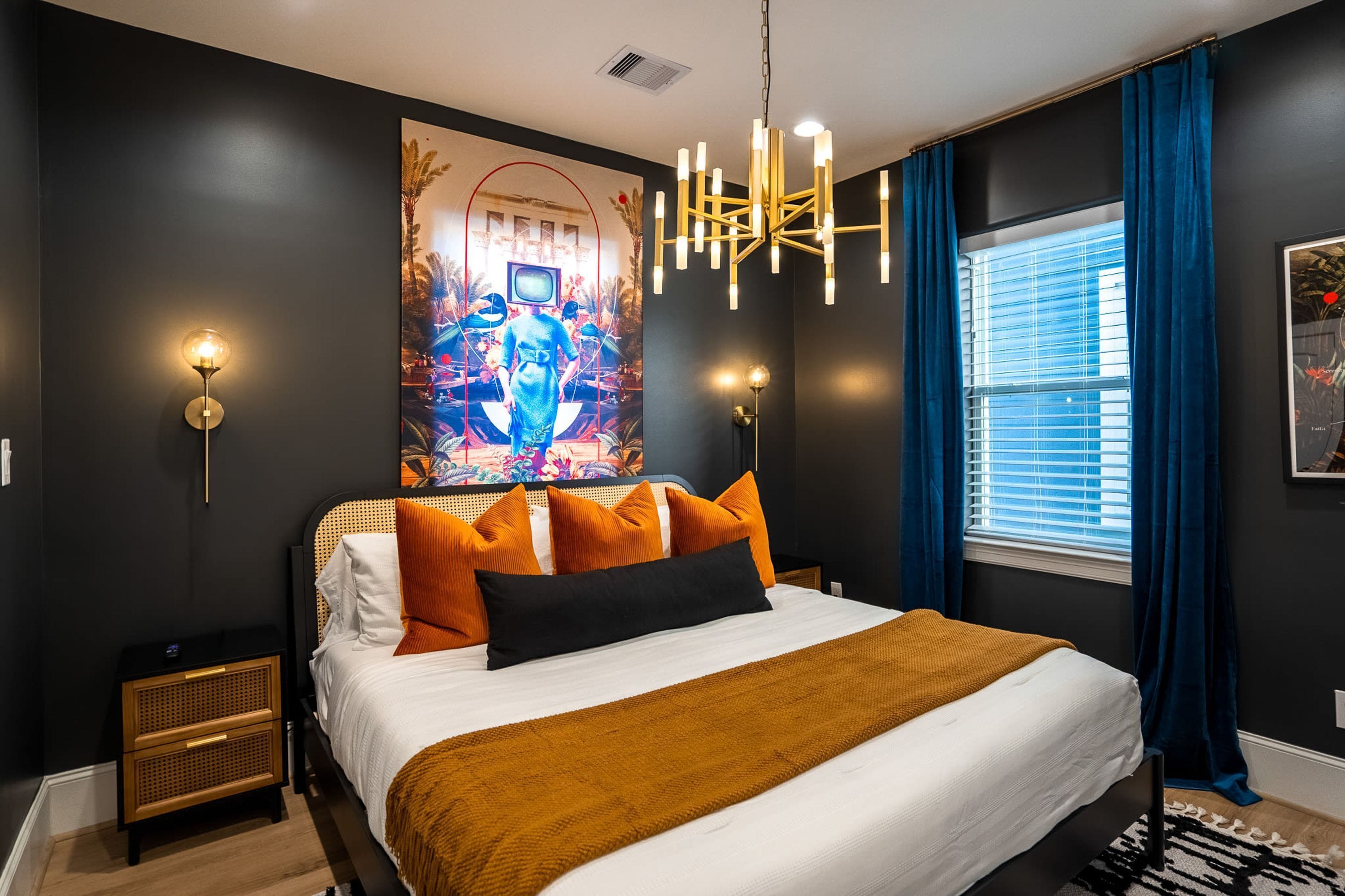 A modern bedroom with a large bed, a unique wall art piece, and a contemporary chandelier.