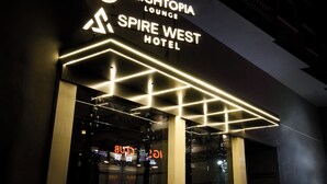 Udsigt over Heightopia Lounges facade på Spire West Hotel, med oplyst skiltning og moderne arkitektur.