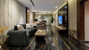 En moderne hotellobby med sofa, sofabord og receptionsdisk.