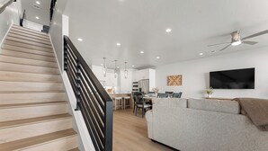 A modern interior with a staircase, a dining area, a living room, and a kitchen. - Desert Family Fun: Desert Color Lagoon + Beaches (St. George)