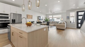 A spacious kitchen with a large island, modern appliances, and pendant lighting. - Desert Family Fun: Desert Color Lagoon + Beaches (St. George)
