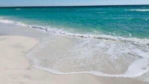 A beach with clear turquoise water and white sand.