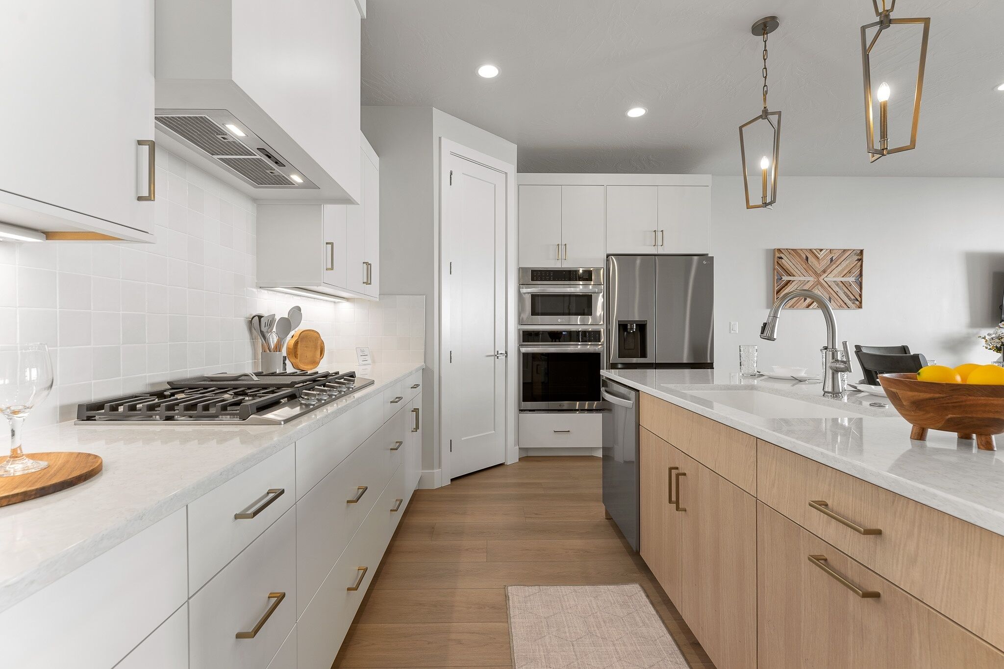A modern kitchen with white cabinets, stainless steel appliances, and a wooden countertop.
