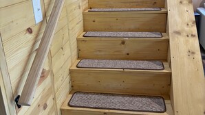 Una escalera de madera con barandilla y peldaños alfombrados.