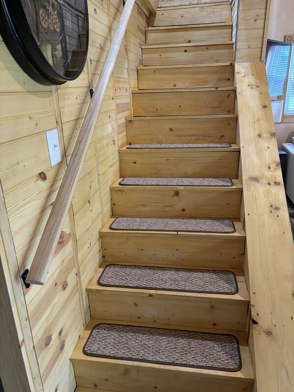 A wooden staircase with a handrail and carpeted steps. - Cozy 2 bedroom pet friendly cabin in great location with all the extra's (Maysville)