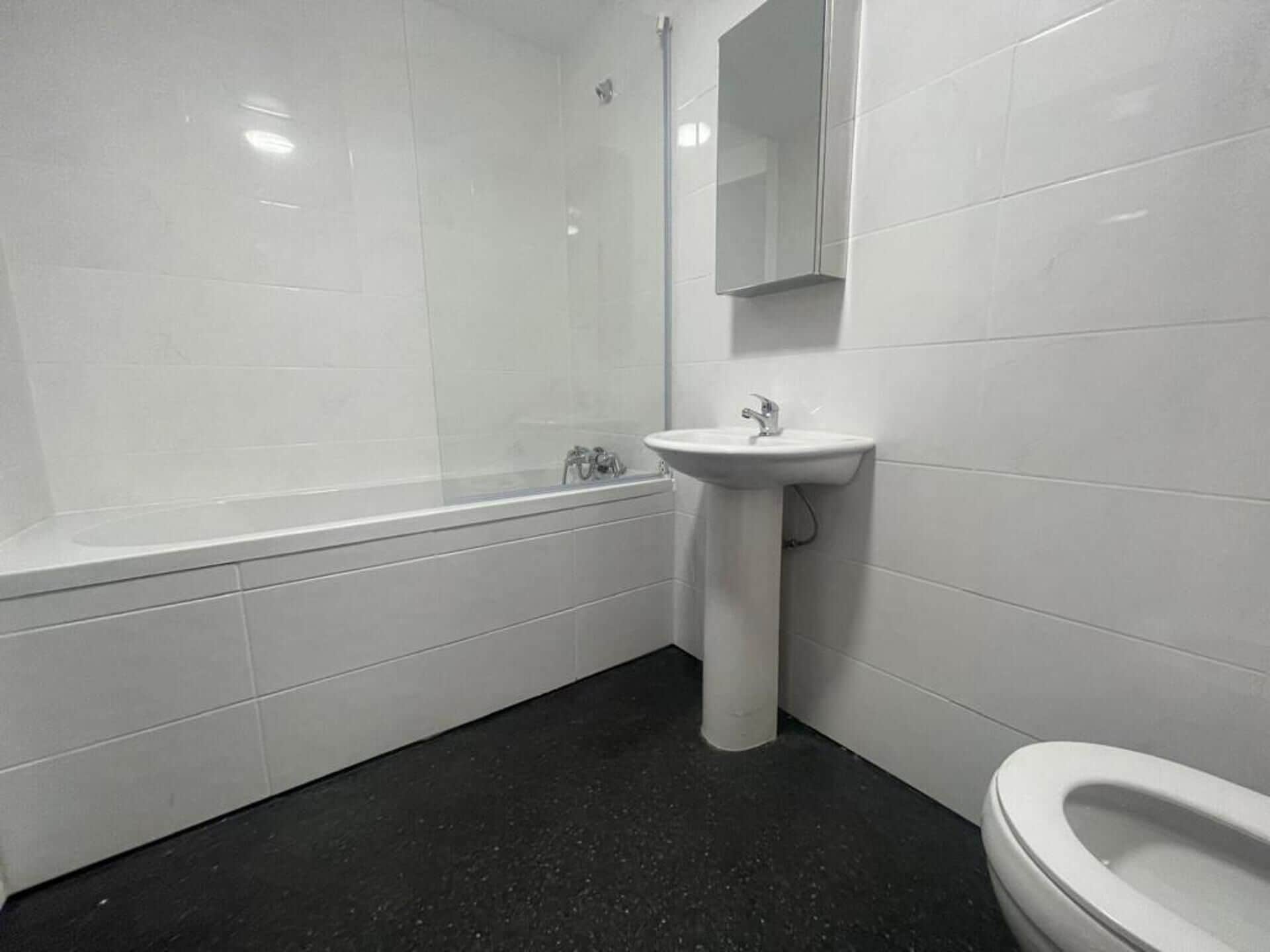 Een badkamer met een bad, wastafel en toilet.