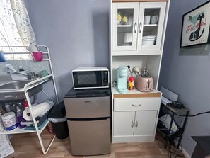 A compact kitchenette with a microwave, toaster, and small refrigerator. - TH Monthly + Utilities + Laundry + Comfy Stay! (Grant)