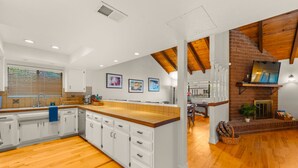 A spacious kitchen with a large island, white cabinetry, and wooden flooring. - Perfect For Families, Walk To Beach, Rooftop Deck* (Oxnard)