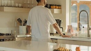 A modern kitchen with a central island, a large window, and decorative vases on the shelves. - Quail Wash Retreat: Star Dome, Sauna, Plunge, Spa (Joshua Tree)
