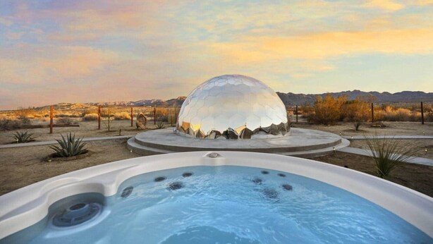 A hot tub with a dome-shaped structure in the background.